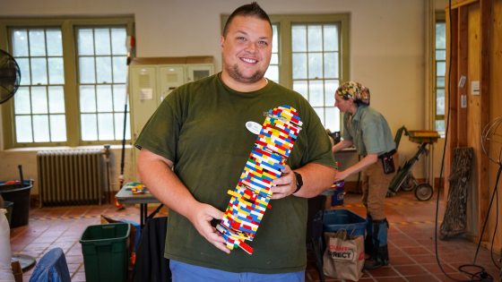 A person showing off their birdhouse tower constructed out of legos.